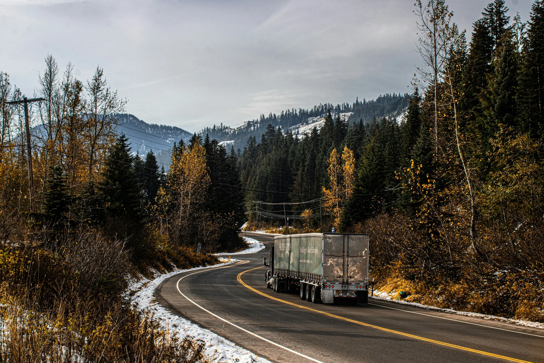 Semi truck traveling along a forested mountain road