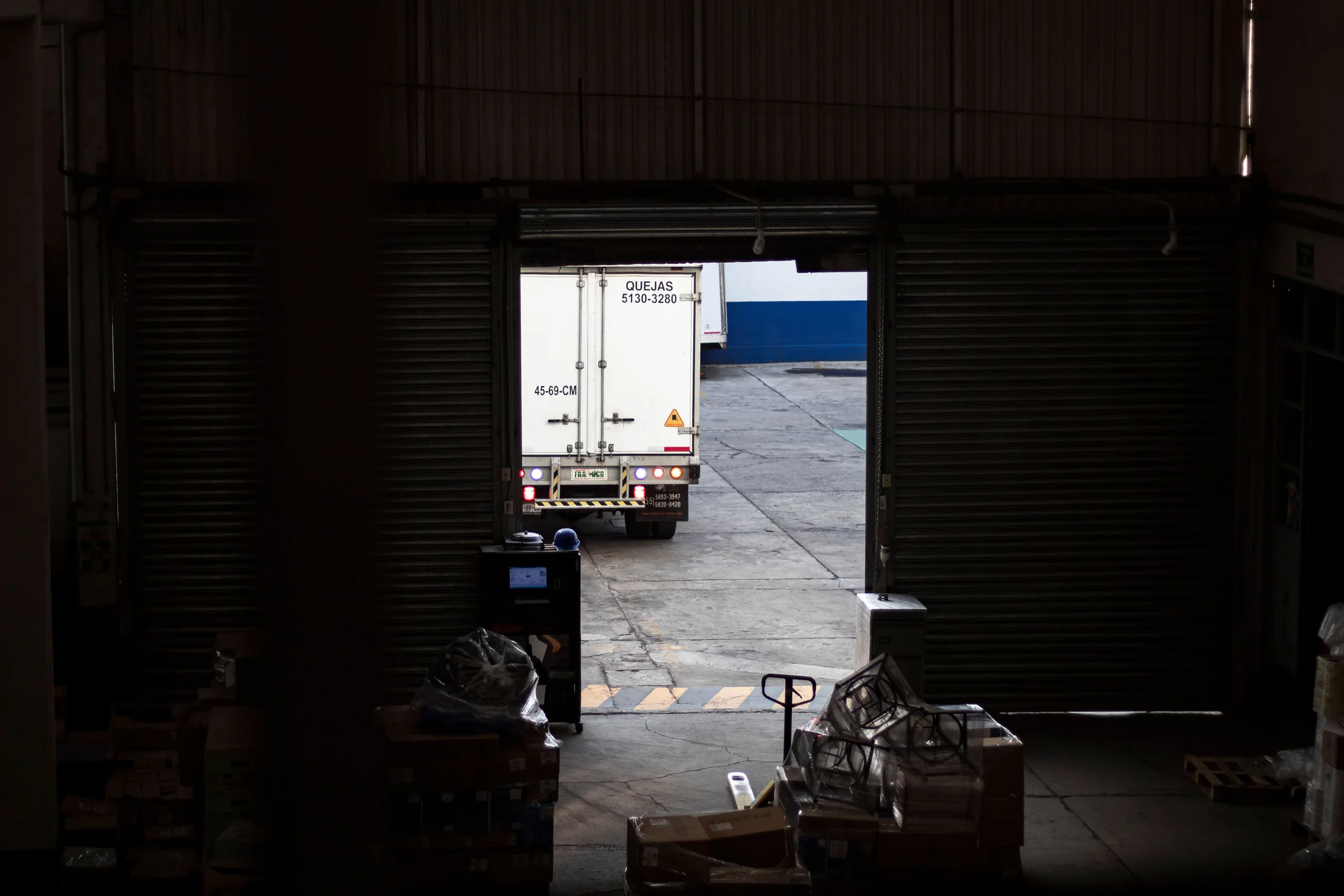 Freight truck departing through a warehouse loading door